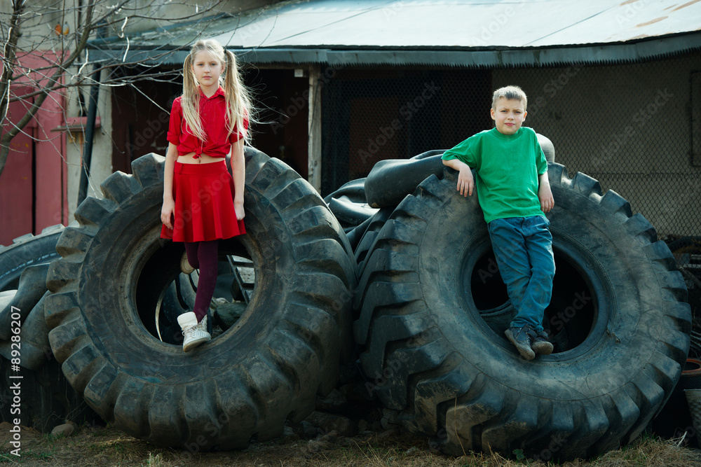children playing in junkyard tires