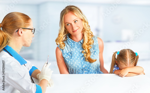 child with her mother on visit at doctor afraid vaccinations