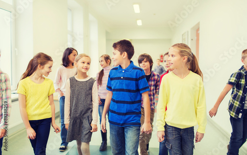 group of smiling school kids walking in corridor © Syda Productions