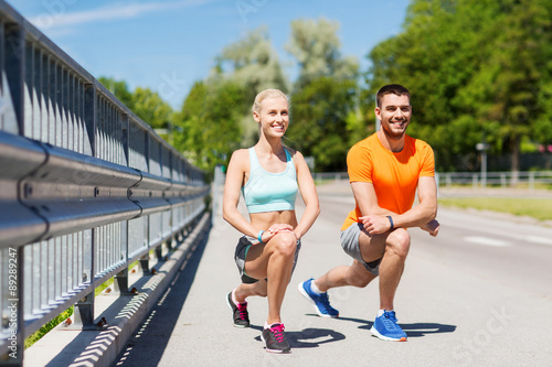 smiling couple stretching leg outdoors