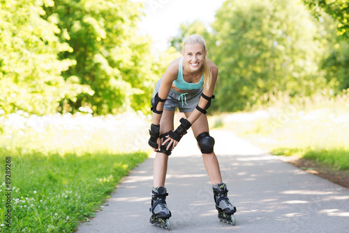happy young woman in rollerblades riding outdoors photo