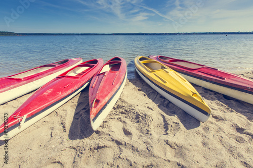 Fototapeta Naklejka Na Ścianę i Meble -  Colorful kayaks moored on lakeshore, Goldopiwo Lake, Mazury, Pol