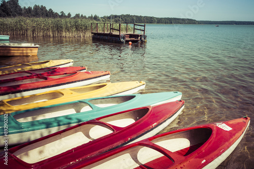 Fototapeta Naklejka Na Ścianę i Meble -  Colorful kayaks moored on lakeshore, Goldopiwo Lake, Mazury, Pol