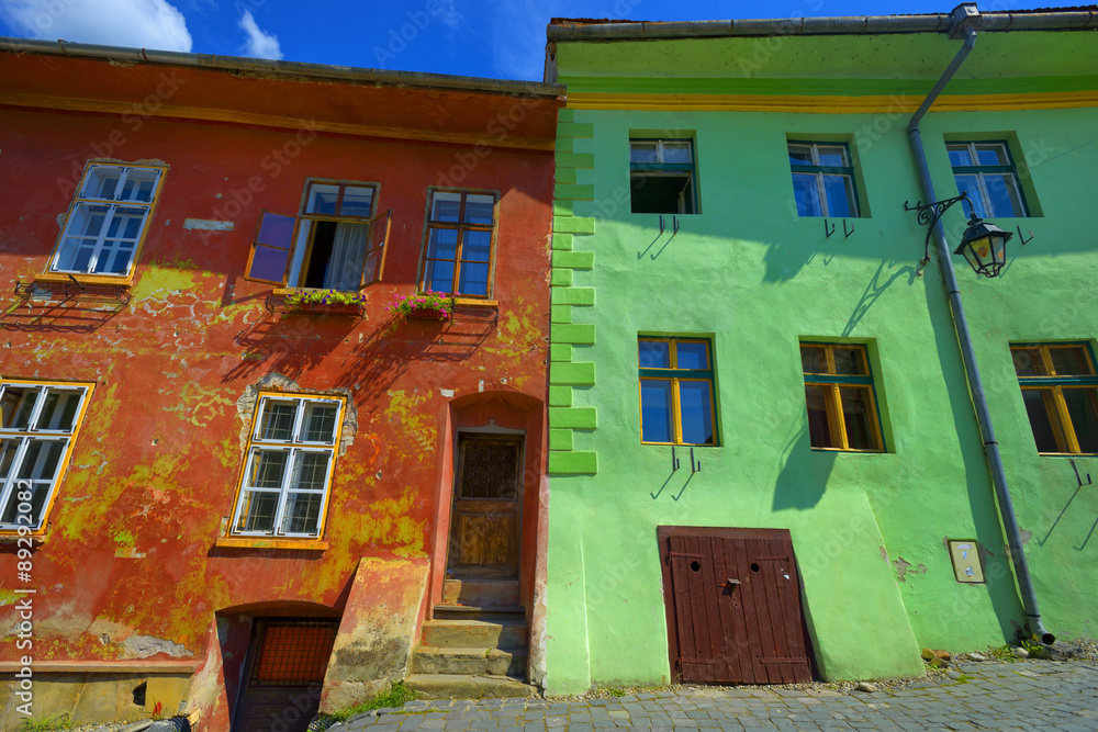 red and green wall with windows house building in Sighisoara, Romania