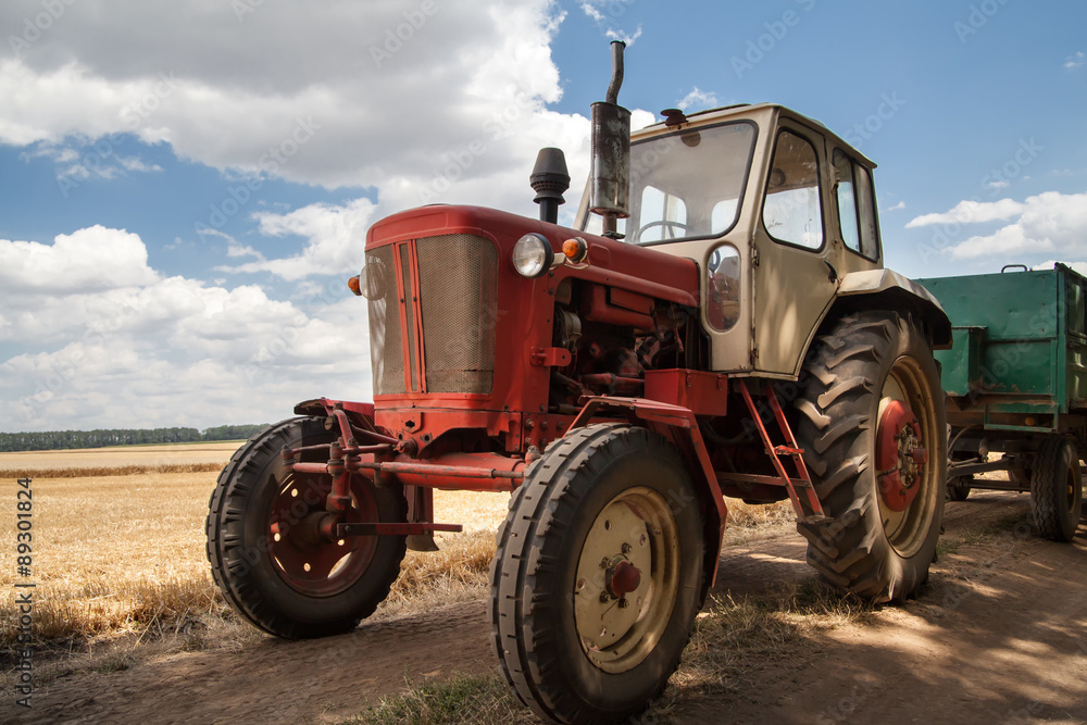 old tractor on the field, against a cloudy sky old tractor on the field, against a cloudy sky