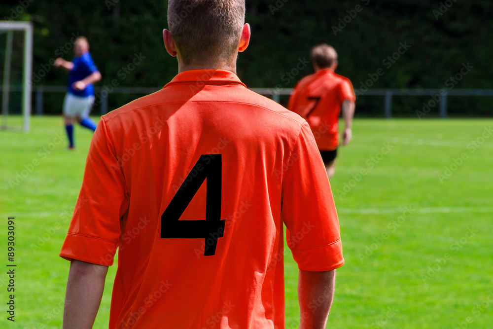 Fototapeta premium Fußballspieler im roten Trikot von hinten 