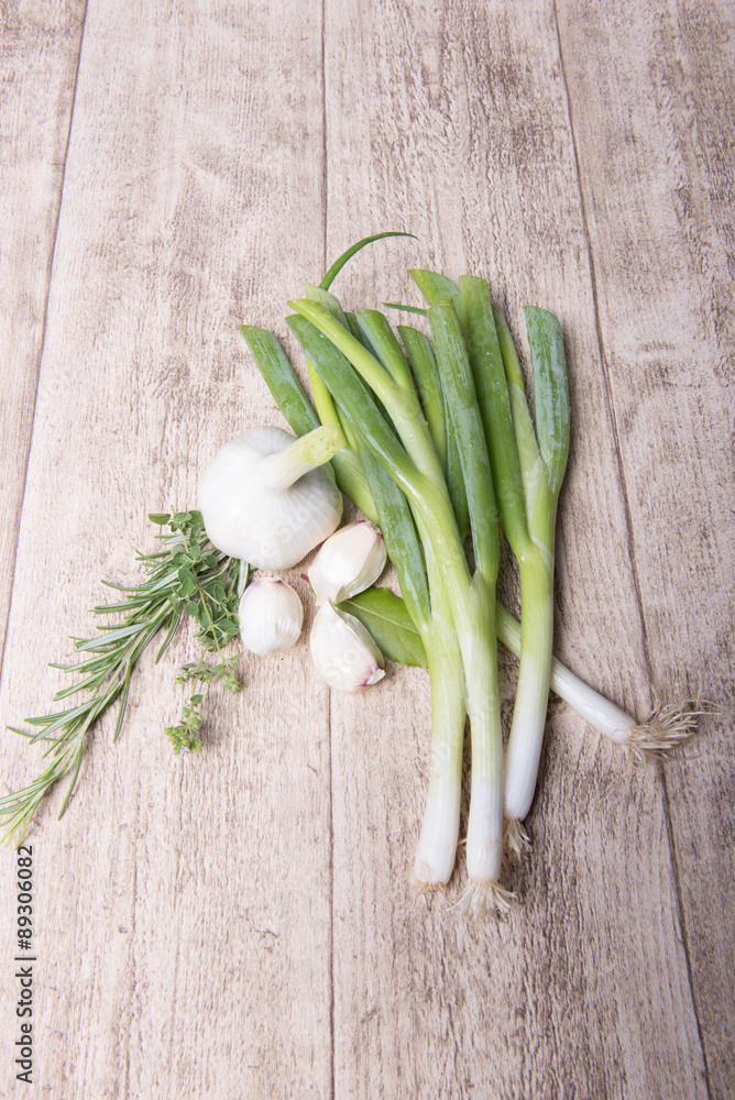 fresh garlic, thyme, laurel, rosemary, onions, scallions on wodd fresh garlic, thyme, laurel, rosemary, onions, scallions on wodd
