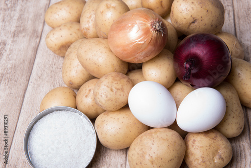 onions  eggs and potatoes on a wooden background