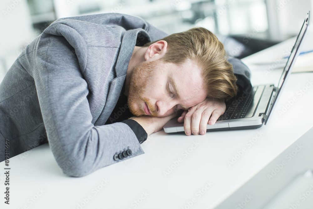 Tired young man sleeping in the office Tired young man sleeping in the office