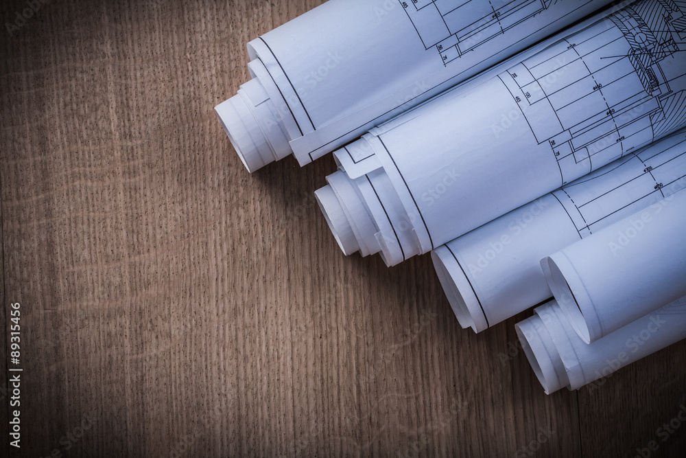 Heap of rolled blueprints on wood board construction concept Heap of rolled blueprints on wood board construction concept