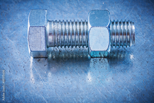 Metal bolt with screw-nut on metallic background construction co photo