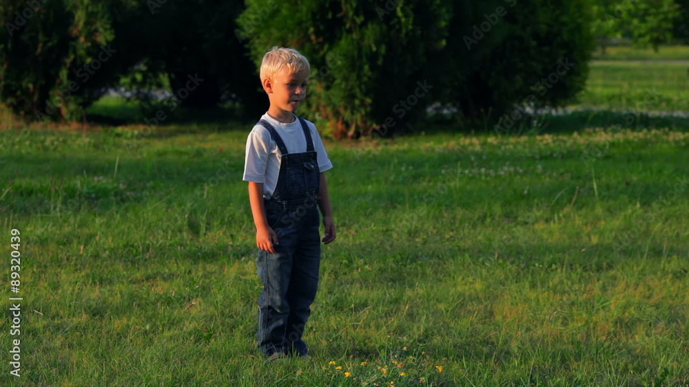 Elementary aged boy kicking ball in the field Elementary aged boy kicking ball in the field
