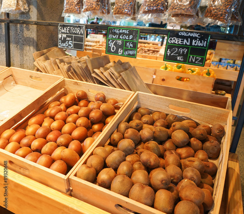 Boxes with golden and green kiwi at natural food market in Auckl photo