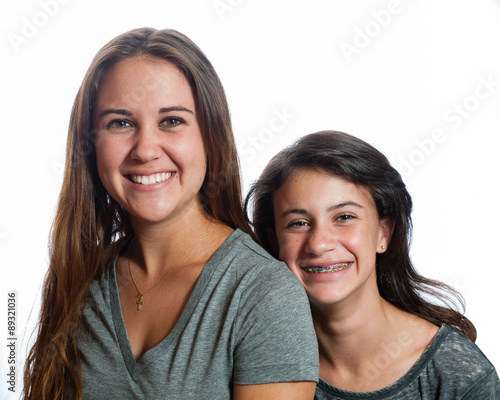 Sisters of different age smiling up close