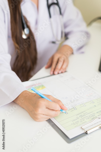 Female doctor filling form with selective focus