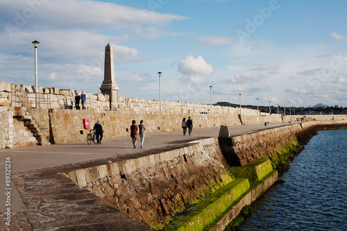 Foto Unidentified people walk along Dun Laoghaire's East pier, Ireland