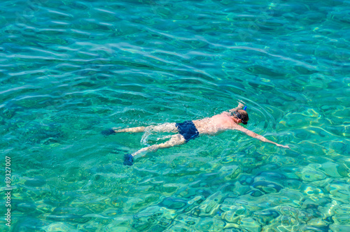 A man snorkeling in the crystal clear sea or ocean