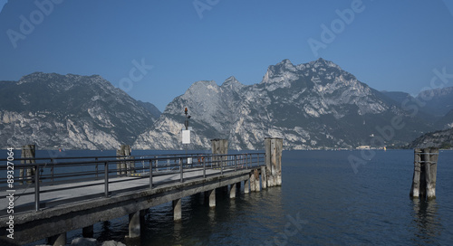Lake Garda, the boats headed to Lemon. View of the mountains, the background Riva del Garda, fjords, colors of the Dolomites. first floor landing and wooden protection.