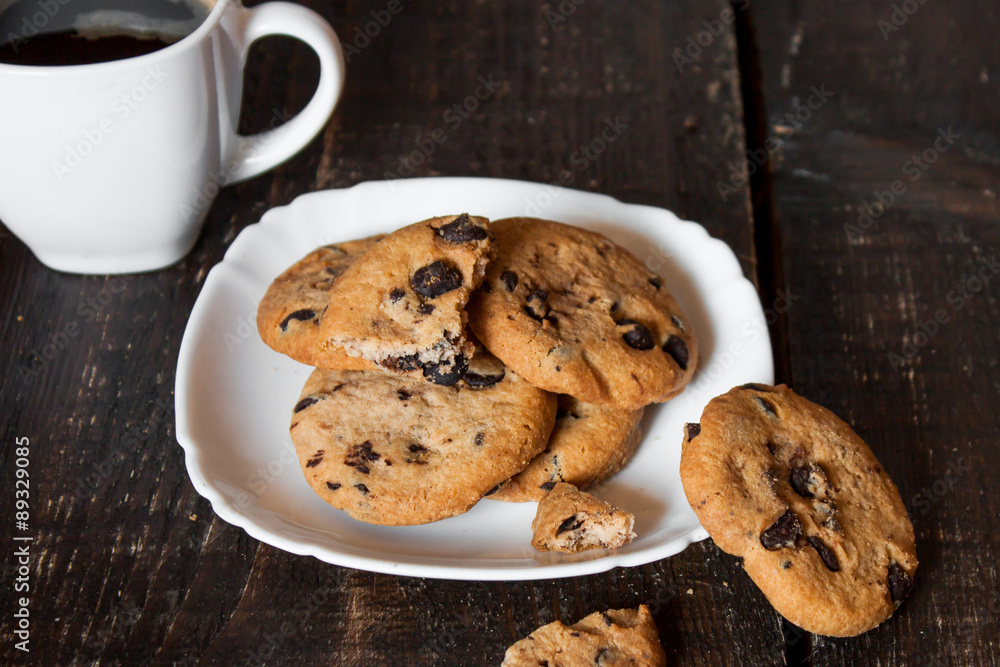 кофе в белой чашке с печеньем на деревянном столе