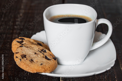 кофе в белой чашке с печеньем на деревянном столе