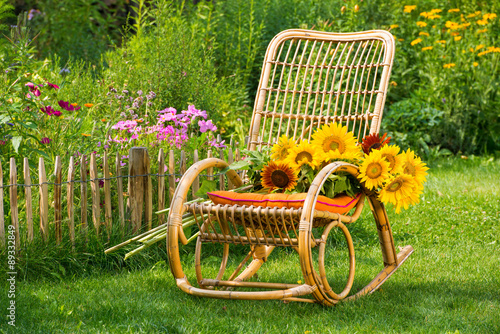 Fototapeta Naklejka Na Ścianę i Meble -  Schaukelstuhl mit Sonnenblumen
