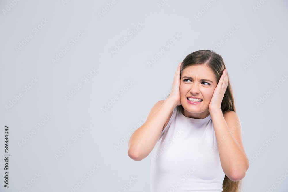 Female teenager covering her ears Female teenager covering her ears
