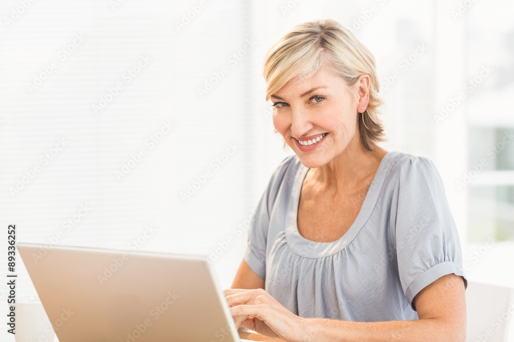 Smiling businesswoman working on a laptop Smiling businesswoman working on a laptop