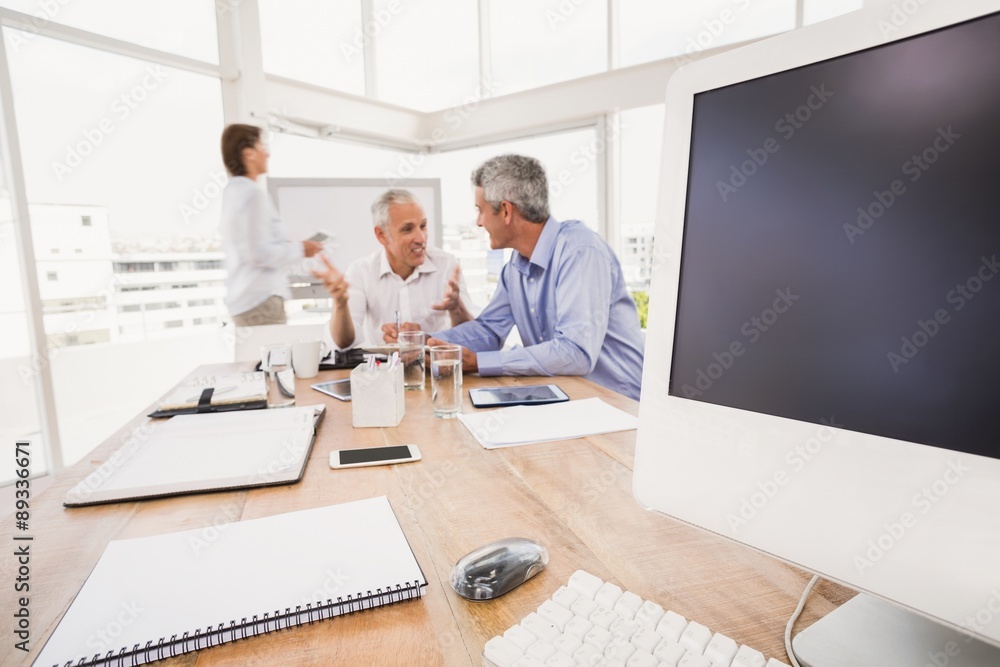 Electronic devices in front of talking business people Electronic devices in front of talking business people