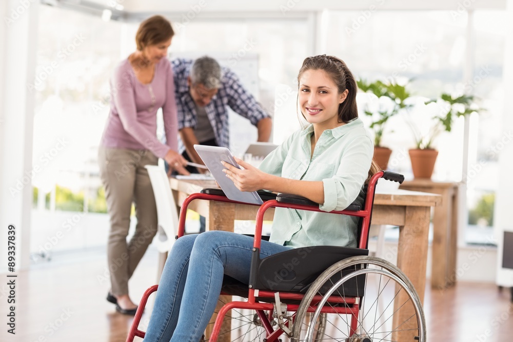 Casual businesswoman in wheelchair using tablet Casual businesswoman in wheelchair using tablet