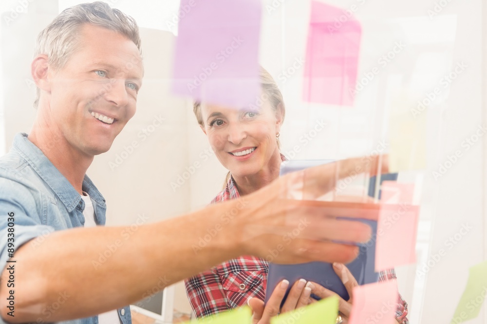 Casual business colleagues reading sticky notes