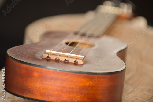 Close up of ukulele on old wood background with soft light, Vint