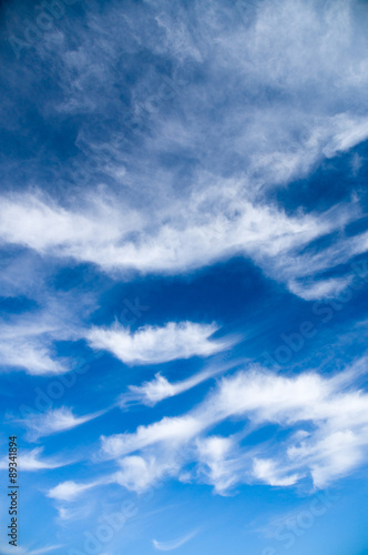 Cirrus and stratus clouds against bright blue sky
