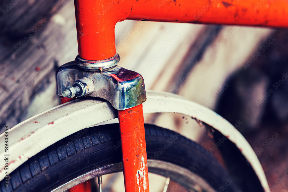 Wheel Old orange bike standing near the wall Wheel Old orange bike standing near the wall