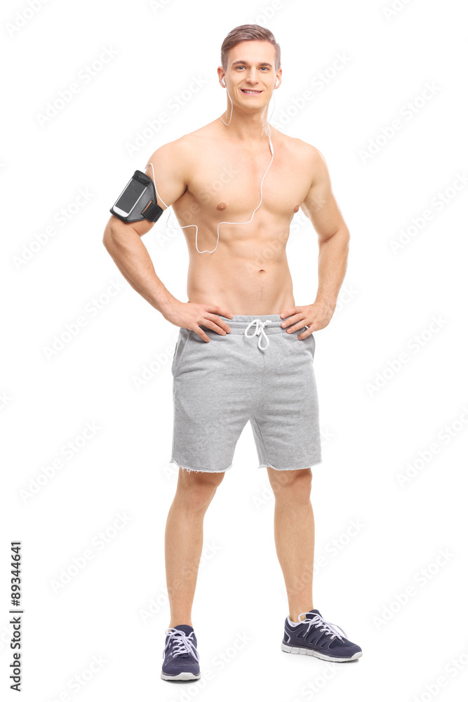 Shirtless young athlete listening music on his phone