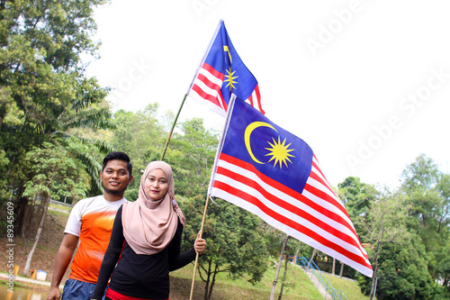 couple friends holding a malaysian flag photo