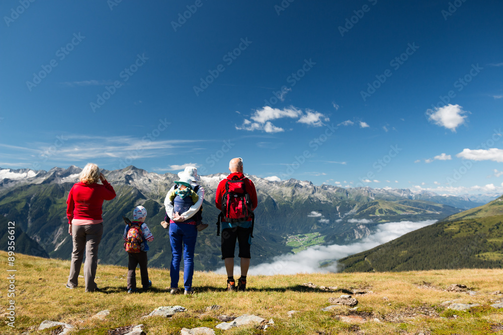happy family with children and baby carrier enjoying beautiful valley in austrian alps