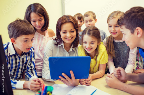 group of kids with teacher and tablet pc at school