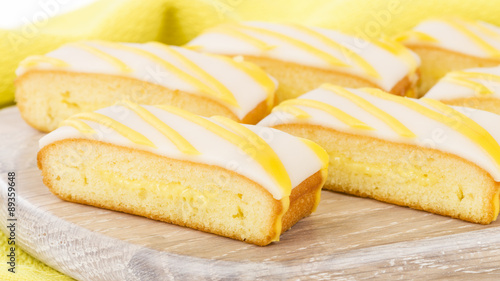 Lemon Drizzle Cake - Slices of lemon cake topped with icing.

