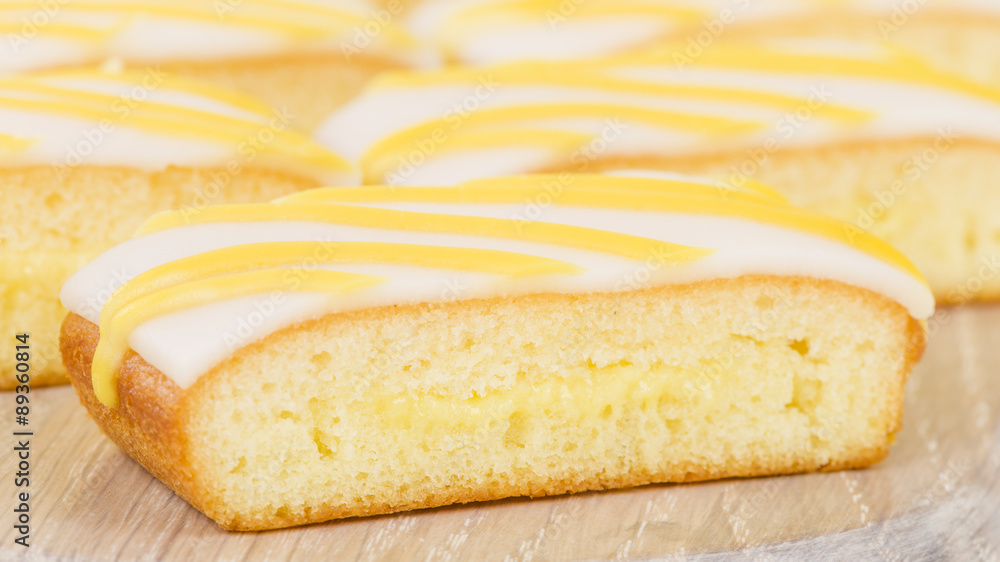 Lemon Drizzle Cake - Slices of lemon cake topped with icing.
