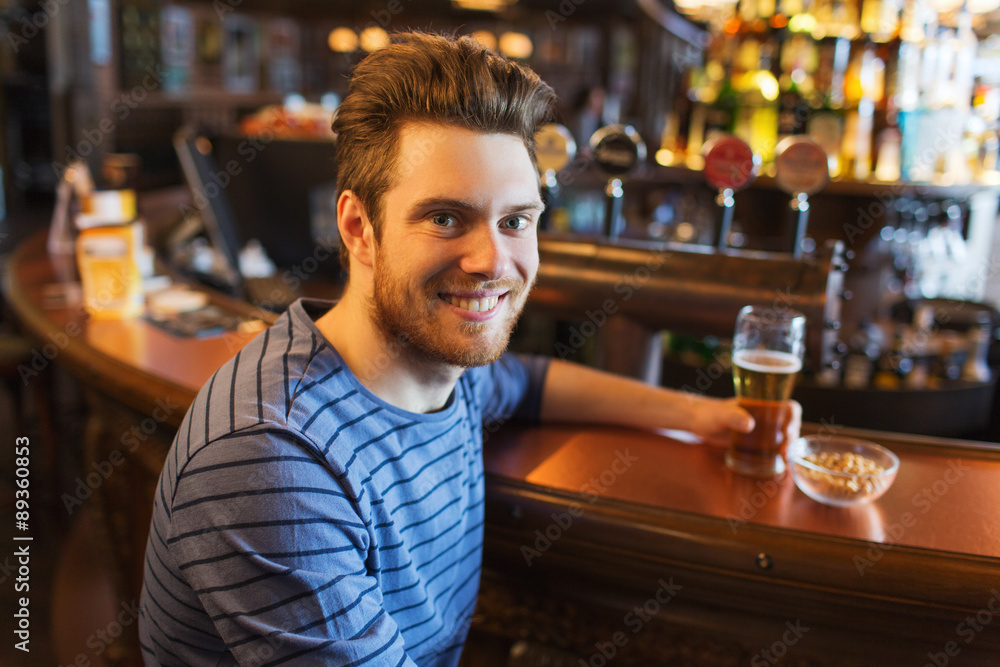 happy man drinking beer at bar or pub