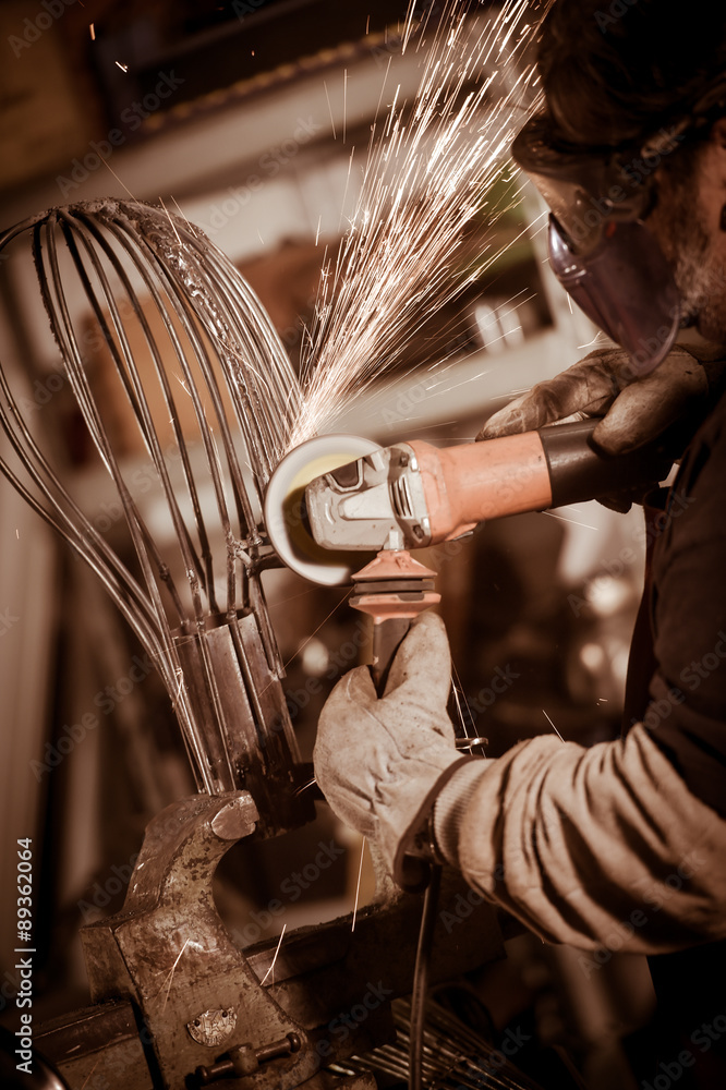 Metal worker Grinding with sparks in workshop - obrazy, fototapety, plakaty 