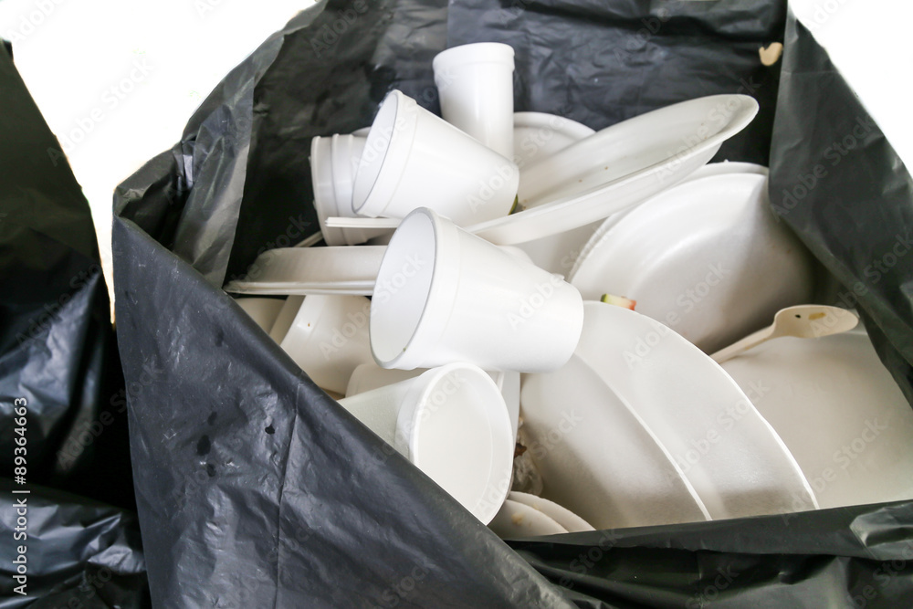 Environmental unfriendly disposed styrofoam plates and cups in garbage bags  Stock Photo