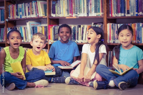 Pupils sitting on the ground and reading books in the library