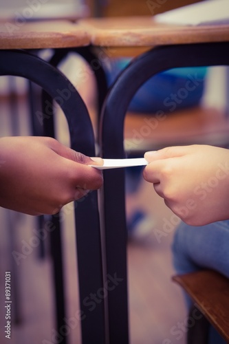 Pupil passing a note to a classmate