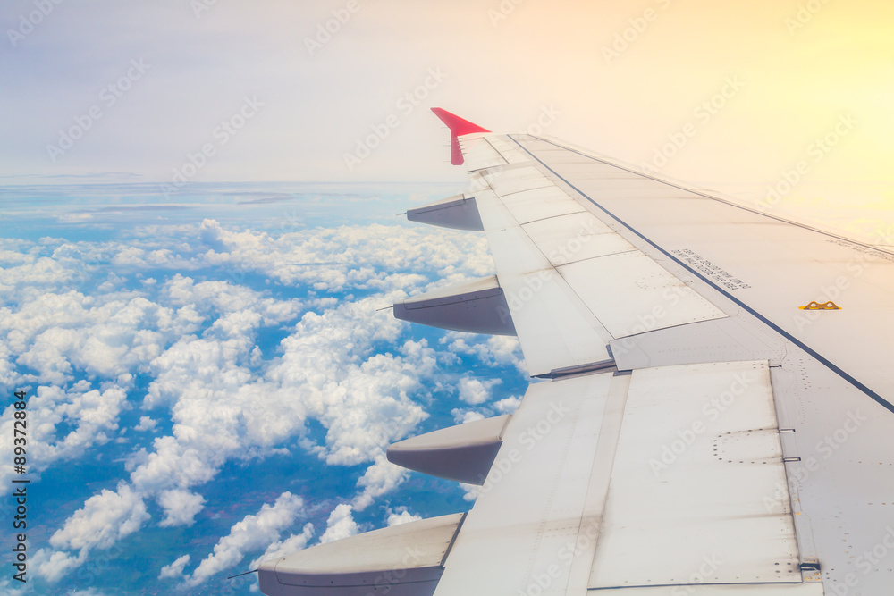 Wing of an airplane flying above the clouds Wing of an airplane flying above the clouds