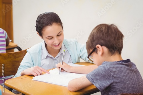 Teacher helping a little boy during class