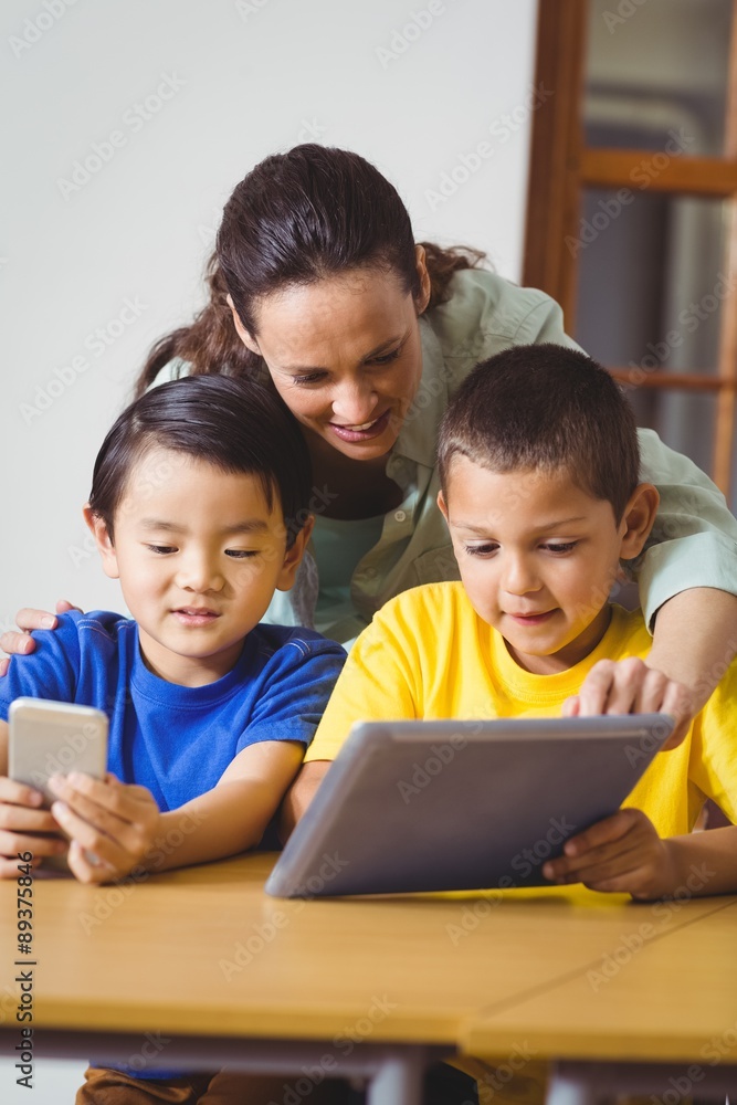 Cute pupils in class using phone and tablet Cute pupils in class using phone and tablet