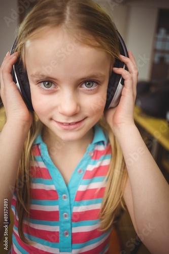 Cute pupil in computer class smiling at camera