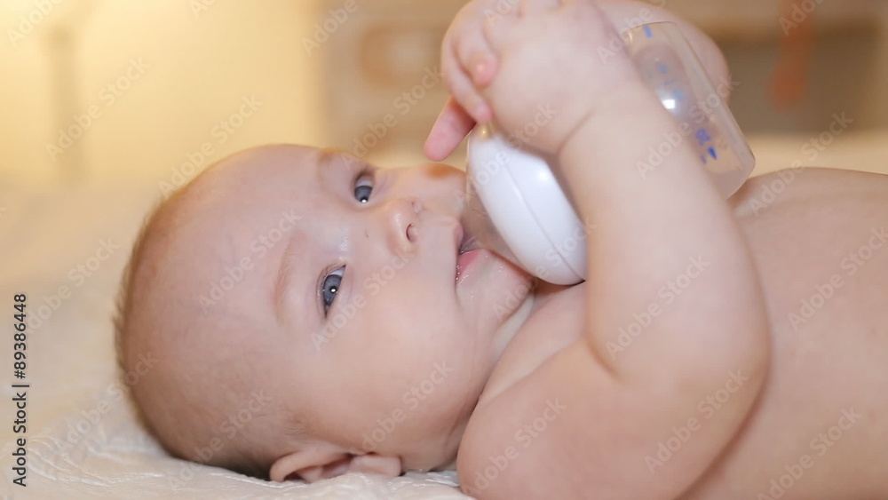 baby holding bottle and drinking water baby holding bottle and drinking water