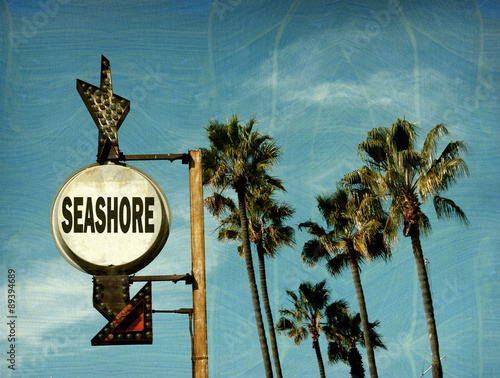 aged and worn vintage photo of seashore sign with palm trees